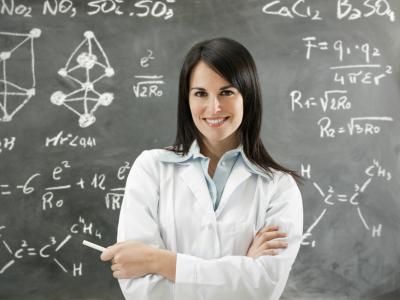 Imagem mostra professora de farmácia em frente ao quadro negro 