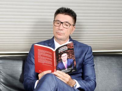 Imagem mostra Janguiê Dinizl lendo o seu livro 