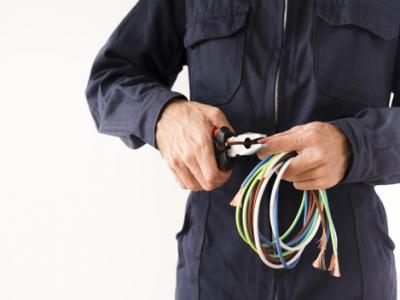 Imagem mostra eletricista com fios nas mãos